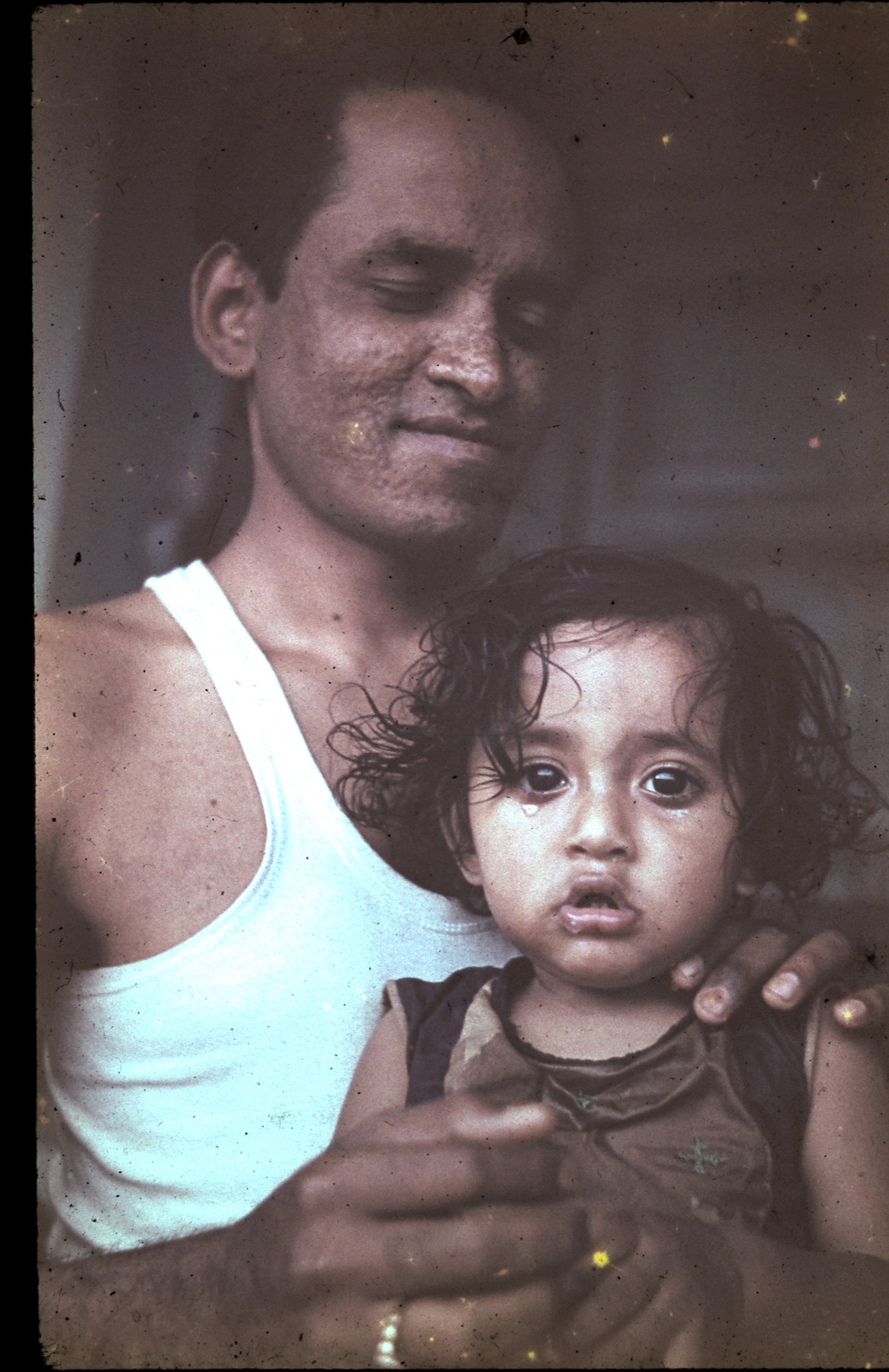 A young Gokulananda Das holding his infant son